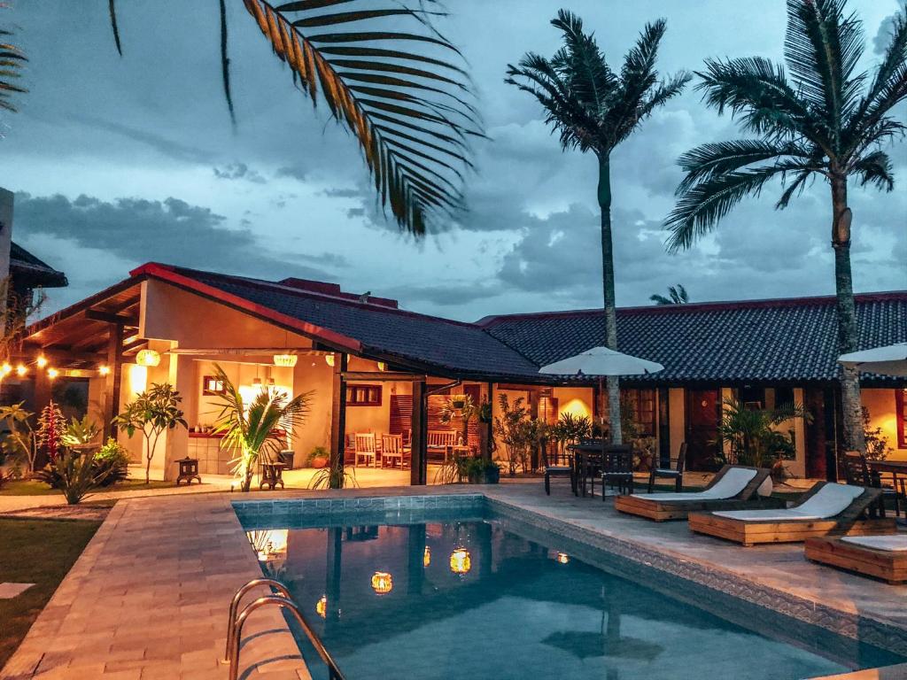 a villa with a swimming pool at night at Casa Mar Campeche in Florianópolis