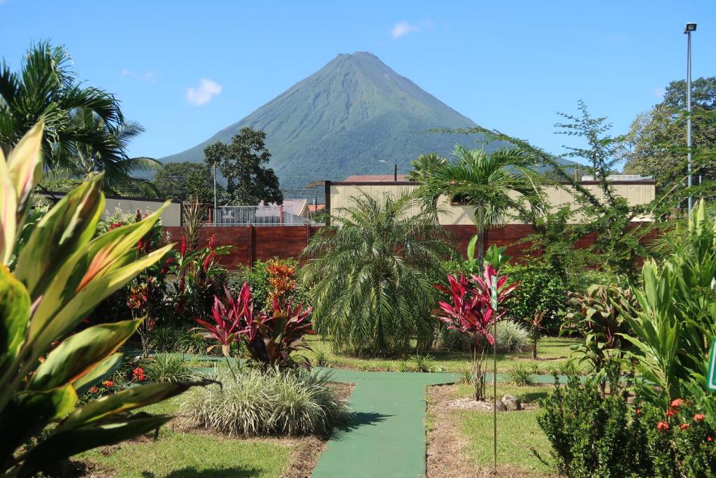 a lush green field with palm trees and palm trees at Hotel Secreto La Fortuna in Fortuna