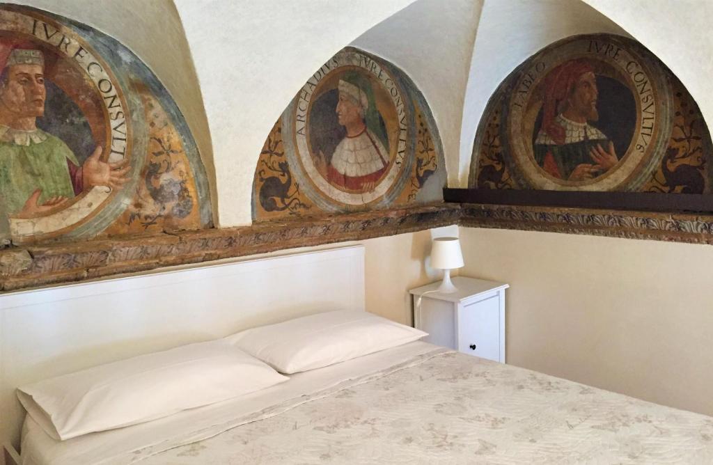 una camera da letto con tre dipinti sul muro e un letto di Bramantesco a Bergamo