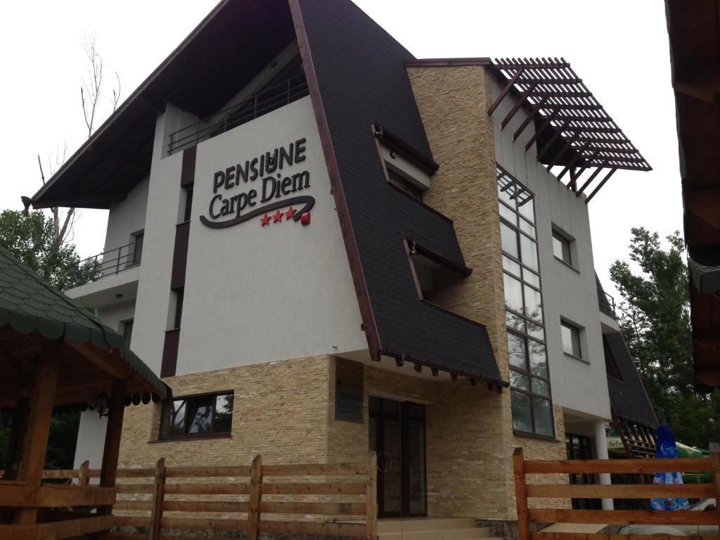 a building with a sign on the side of it at Pensiunea Carpe Diem in Râmnicu Vâlcea