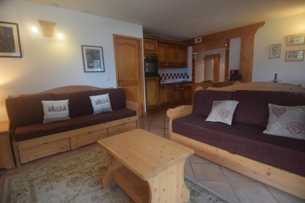a living room with two couches and a table at Spacious Apartment 2 Minutes from Ski Lift, Equipped for Babies in Les Houches