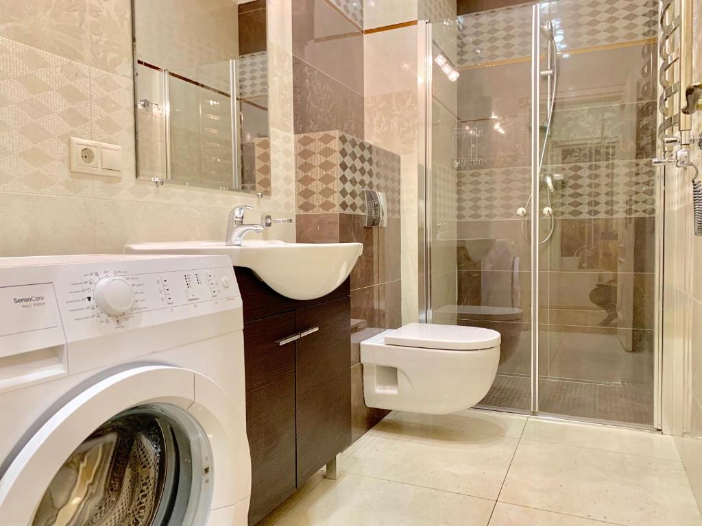 een badkamer met een wasmachine en een wastafel bij Two-bedroom on Lesi Ukrainky in Lviv