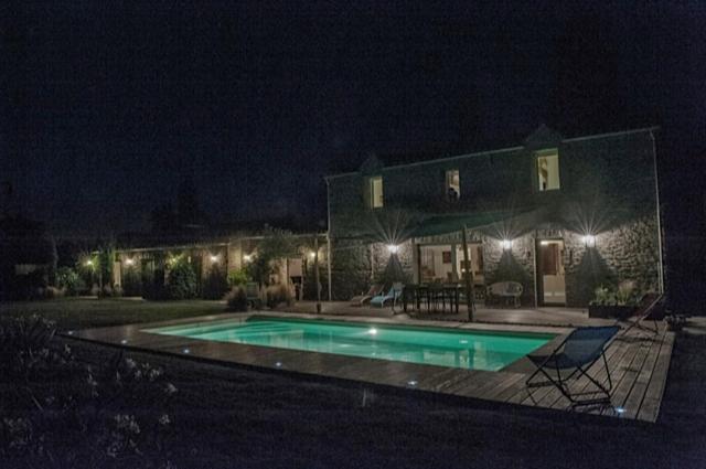 uma casa com piscina à noite em LE CLOS DE LA HOURSERIE em Pornic