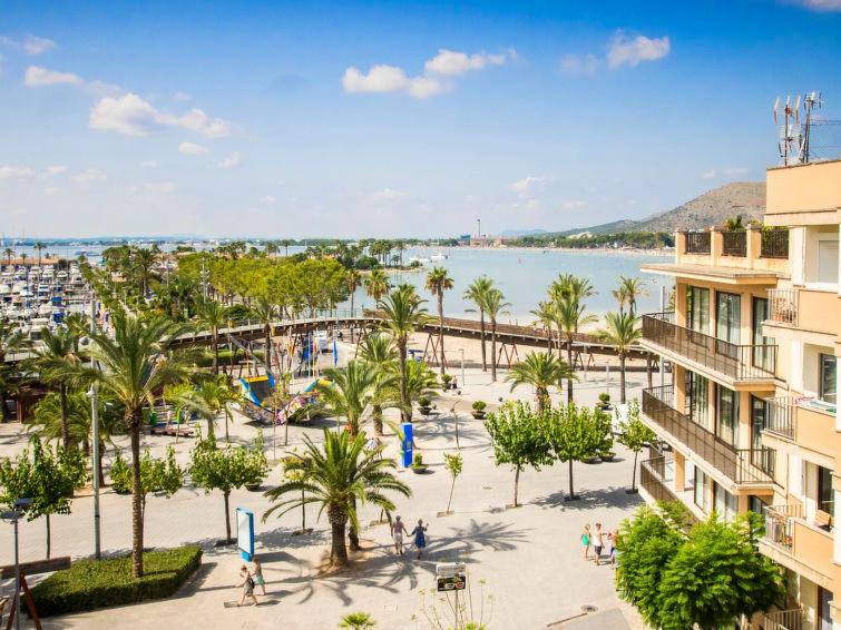 een uitzicht op een strand met palmbomen en een gebouw bij Mariners in Port d'Alcudia