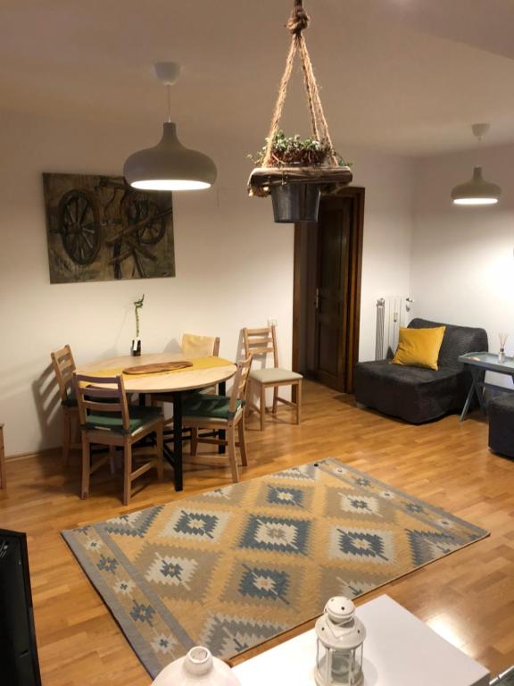 a dining room and living room with a table and chairs at STILL Apartament Sinaia in Sinaia