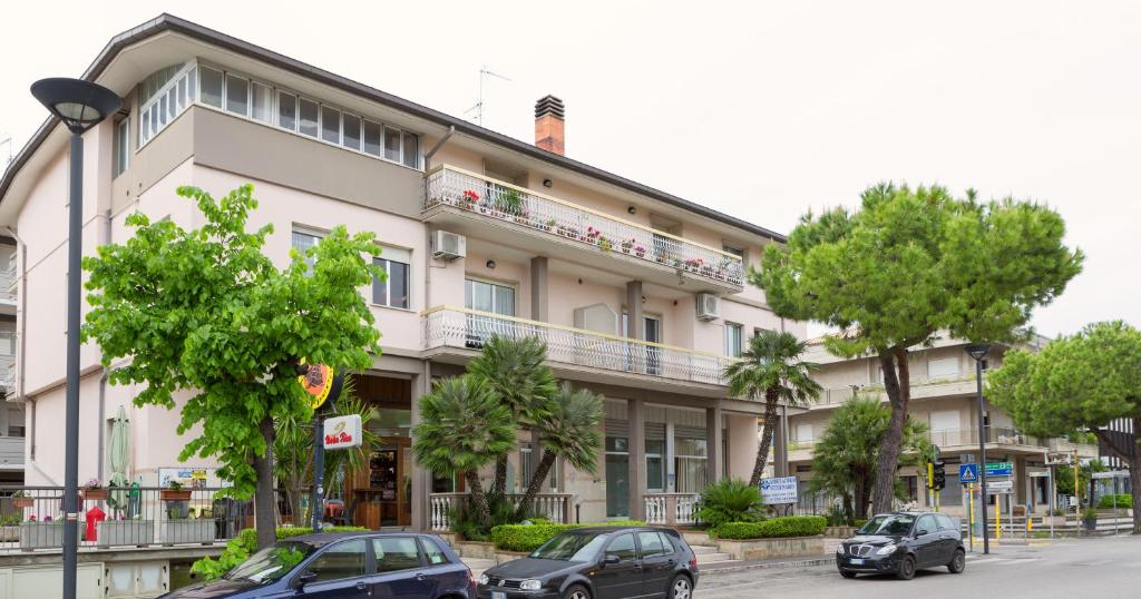 a building with cars parked in front of it at B&B Mazzini in Alba Adriatica