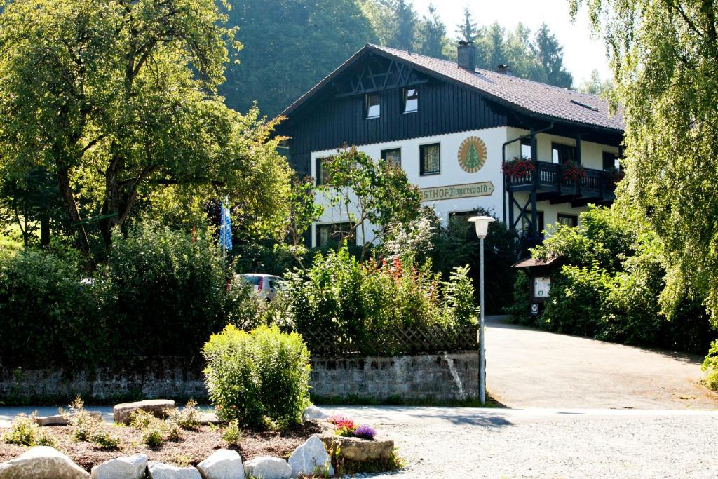 um grande edifício preto e branco com um jardim em Landhotel Bayerwald em Grafling