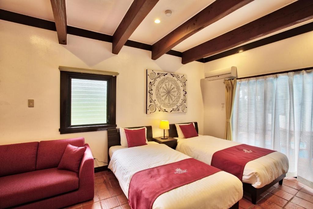 2 Betten in einem Zimmer mit Sofa und Fenster in der Unterkunft Kunigami-gun - Hotel / Vacation STAY 11200 in Onna