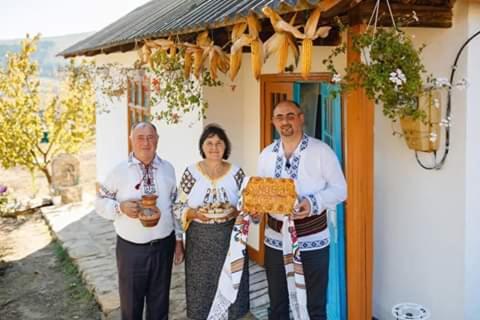 a group of three people standing in front of a house at Pensiunea turistica "Casa rustica" in Chişcăreni