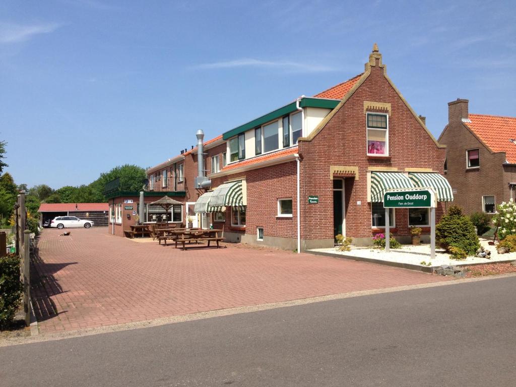 ein Backsteingebäude auf einer Straße mit einem Picknicktisch in der Unterkunft Hotel-Pension Ouddorp in Ouddorp