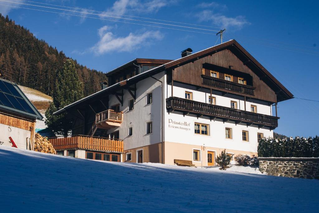 a large building on top of a snow covered slope at Prünsterhof in Obertilliach