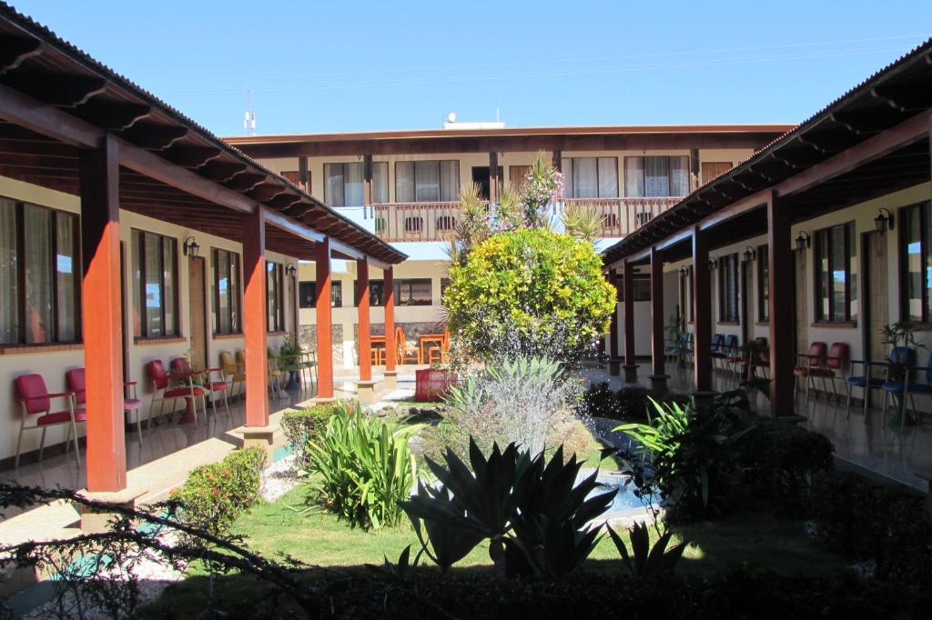 un patio de un edificio con muchas plantas en Hotel La Siesta en Liberia
