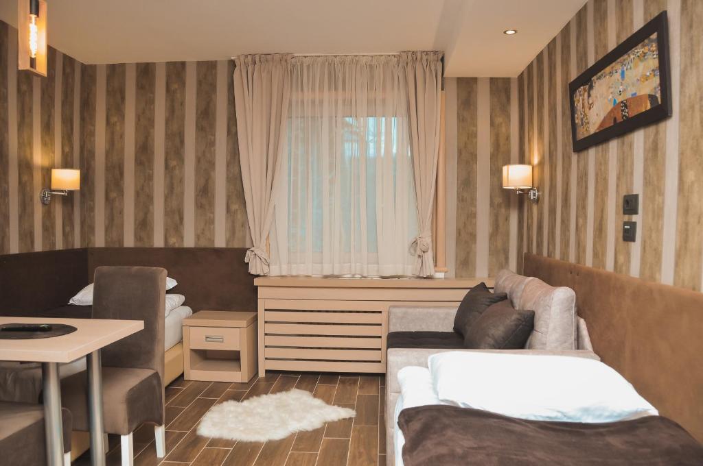 a hotel room with a couch and a table and a table sidx sidx at Apartman Mitra Angella Konaci in Kopaonik