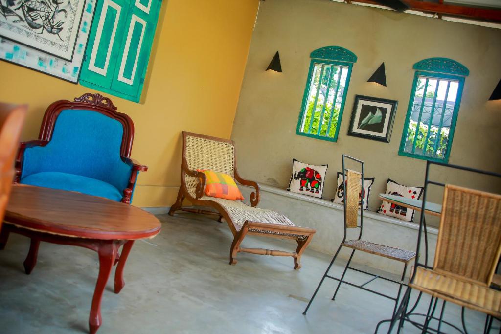 a room with chairs and a table and windows at Kurumba Villas in Bentota