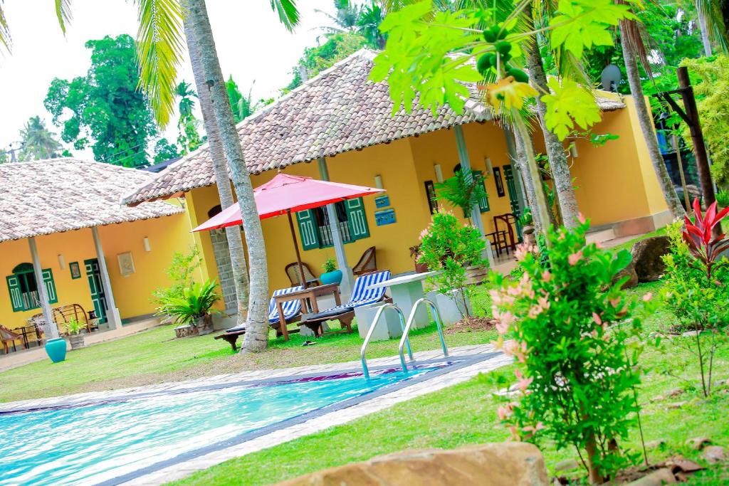 a house with a pool in front of it at Kurumba Villas in Bentota