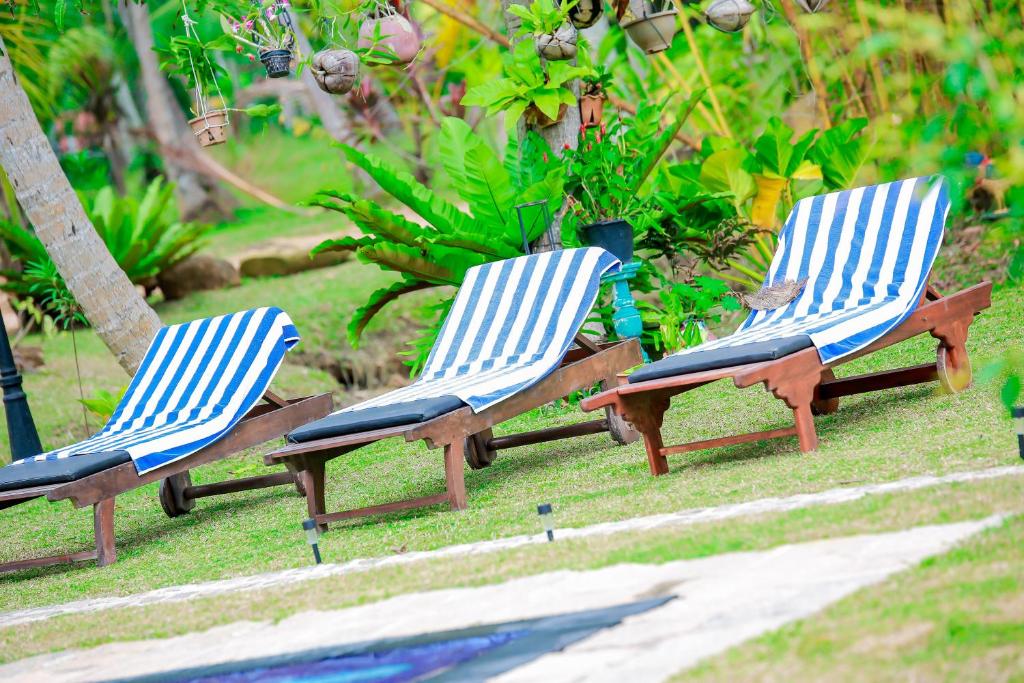 two chairs sitting in the grass in a yard at Kurumba Villas in Bentota
