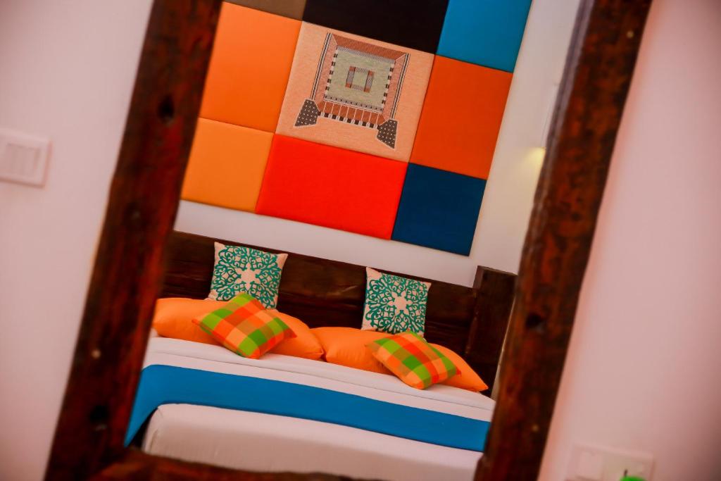 a mirror reflection of a bed with colorful pillows at Kurumba Villas in Bentota