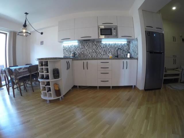a kitchen with white cabinets and a table in a room at Redco №1 Apartament Gondola LIft in Gudauri