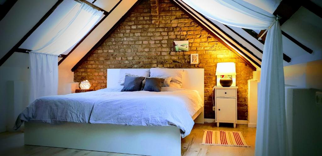 ein Schlafzimmer mit einem Bett mit Ziegelwand in der Unterkunft Kelsterhaus in Kelsterbach