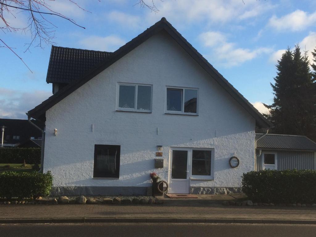 una casa blanca con techo negro en Ferienwohnung Busdorf, en Busdorf