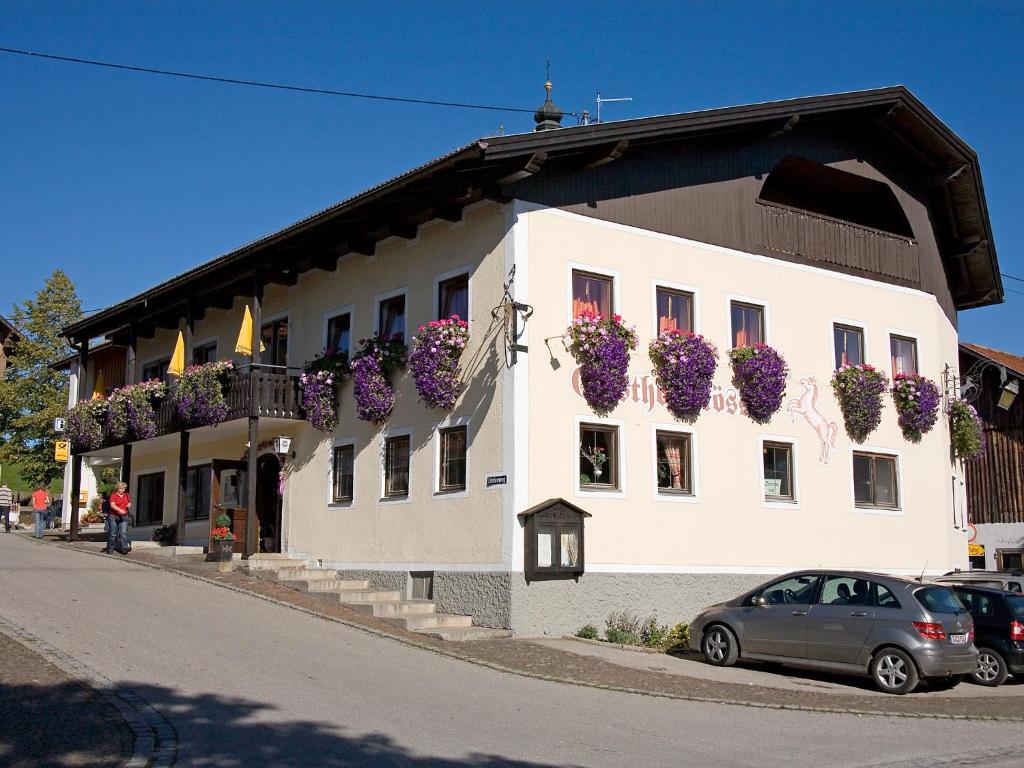 a building with flower boxes on the side of it at Gasthof Rössle in Rieden am Forggensee