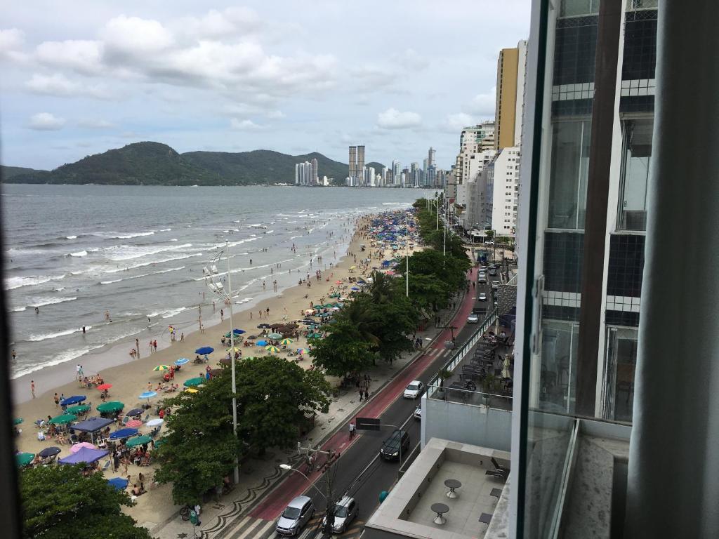 - Vistas a una playa con personas y sombrillas en Apartamento Frente MAR, na Praia CENTRAL, en Balneário Camboriú