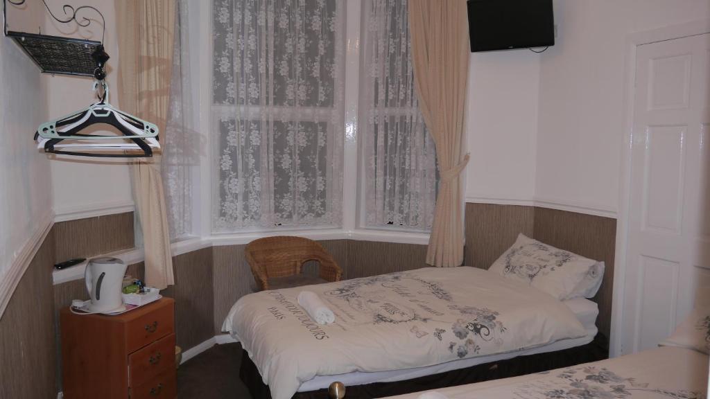 a small bedroom with a bed and a window at Hornby House Hotel in Blackpool