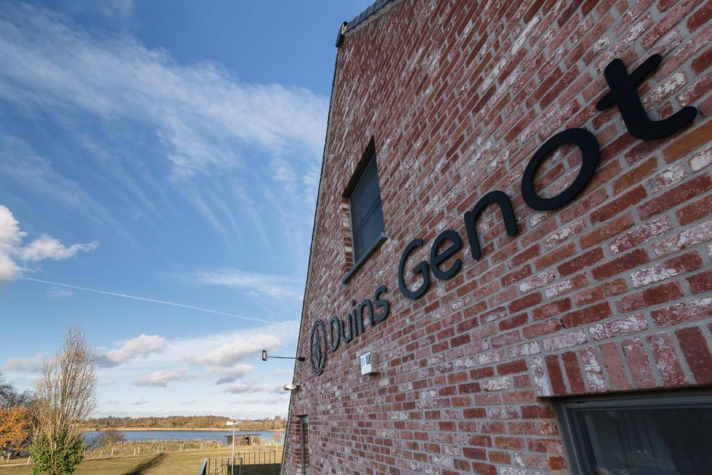 a brick building with a sign on the side of it at Duins Genot 5 star Holiday Homes 30p & 40p - Indoorpool & Wellness in Jabbeke