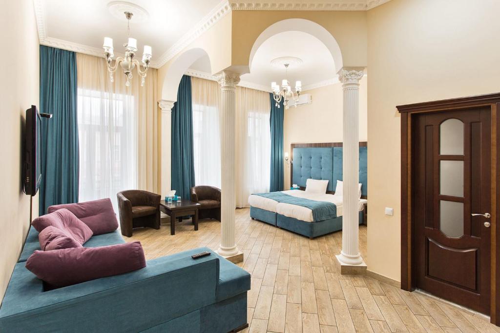 sala de estar con sofá y cama en Hotel Baron en Odesa