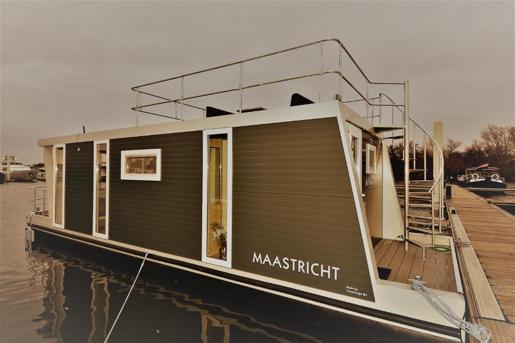 una pequeña casa en un barco en el agua en Cozy floating boatlodge "Maastricht". en Maastricht