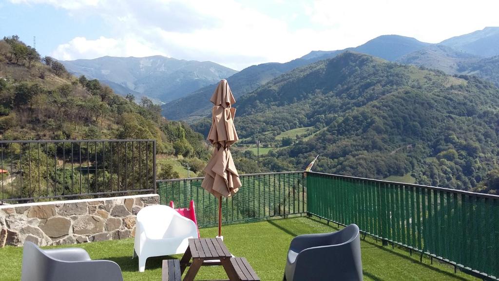 Buellas的住宿－Casa Manolita，庭院配有桌子、遮阳伞和椅子