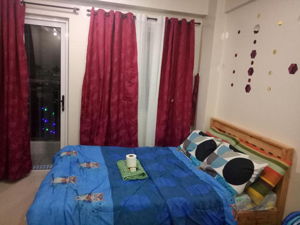 een slaapkamer met een bed met een blauw dekbed bij Kassel residence Mhavic Family room good for 5guest in Manilla