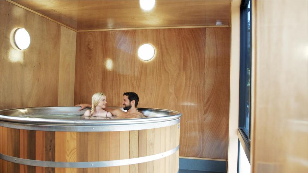 a man and woman in a bath tub with a dog at Apartments at Queenstown TOP 10 Holiday Park in Queenstown