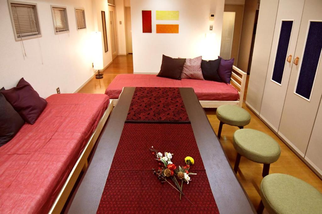Cette chambre comprend 2 lits et une table fleurie. dans l'établissement Guest room Kamakura Nagomi -Camellia-, à Kamakura