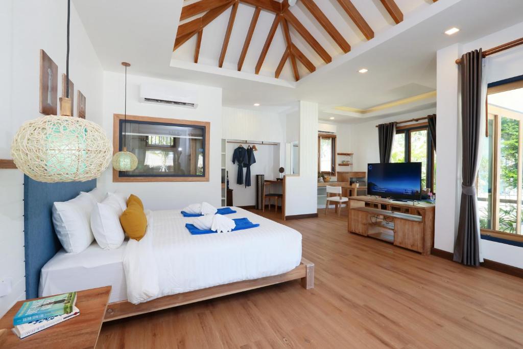 a bedroom with a white bed and a television at Lanta Casa Blanca in Ko Lanta