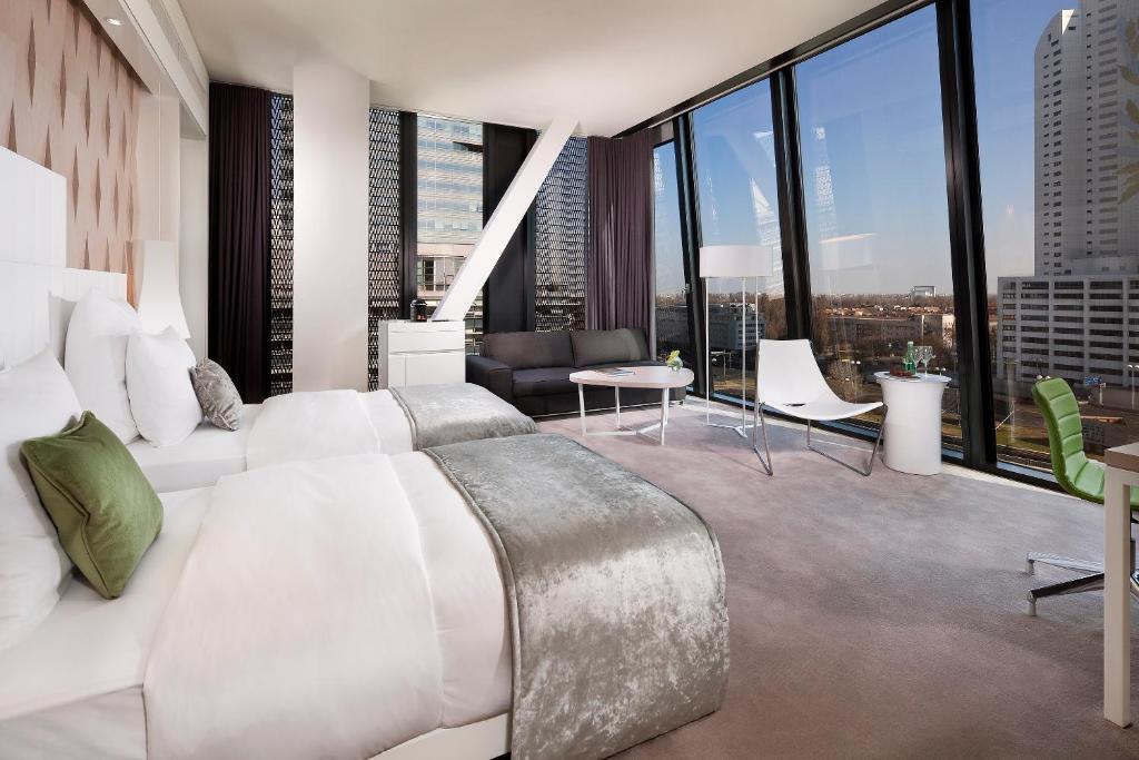 a bedroom with a white bed and large windows at Melia Vienna in Vienna