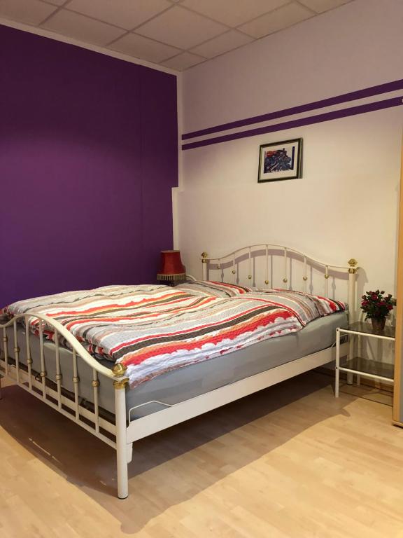 ミュンヘンにあるMunich Apartment Harras (Souterrain)の紫の壁のドミトリールームのベッド1台分です。