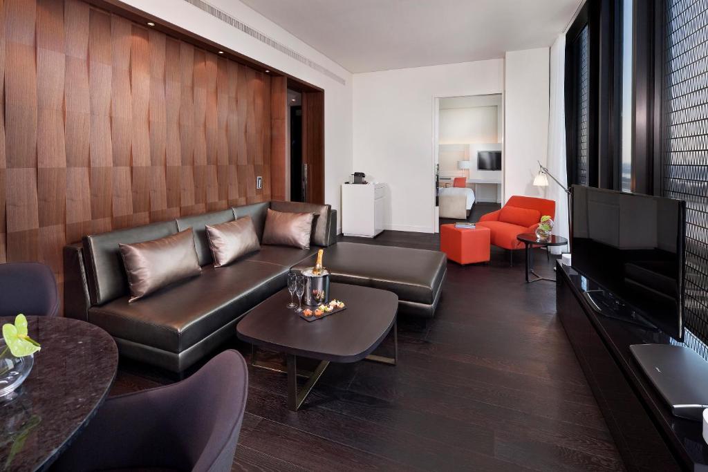 a living room with a leather couch and a television at Melia Vienna in Vienna