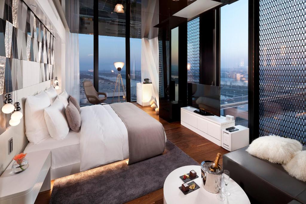 a bedroom with a large white bed and large windows at Melia Vienna in Vienna