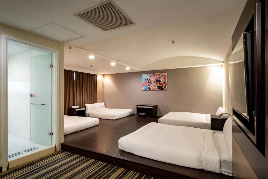 a hotel room with two beds and a glass door at Yoyo Hotel in Chiayi City