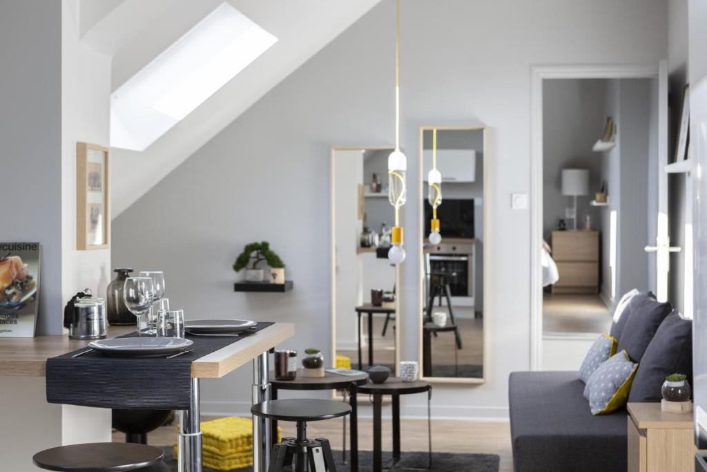 un salon avec une table et un canapé dans l'établissement Azulejo by Cocoonr, à Nantes