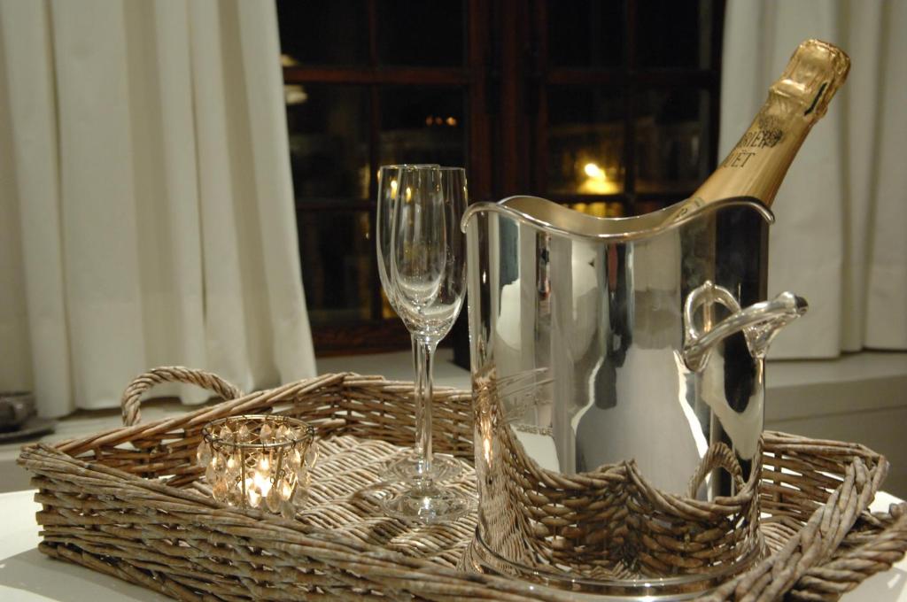 a basket with a wine bottle and glasses on a table at B&B De Waterzooi in Ghent