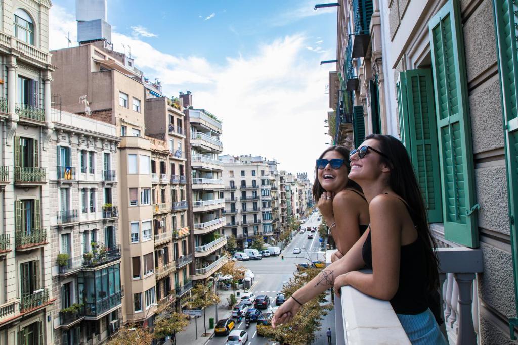 Sant Jordi Hostels Rock Palace في برشلونة: سيدتان واقفتان على شرفة تطل على مدينة