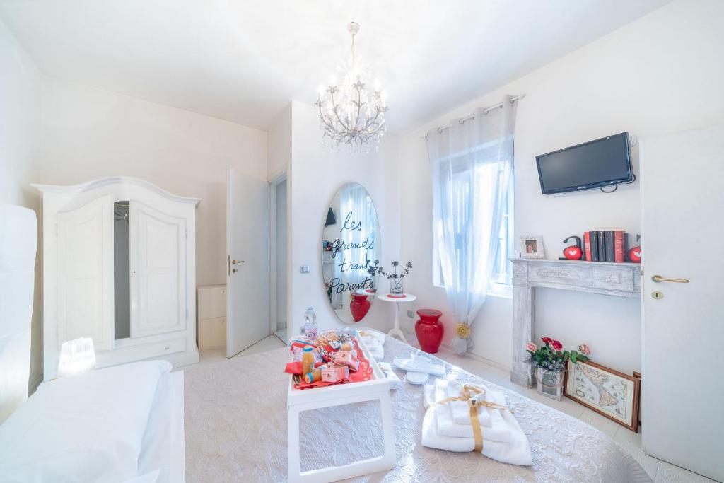 ヴェローナにあるAbbraccio di Giuliettaの白いベッドと暖炉が備わる白い部屋