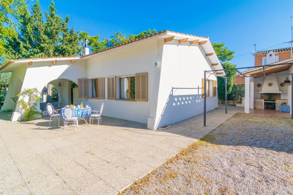 a white house with a table and chairs at Es Baladre in Port d'Alcudia