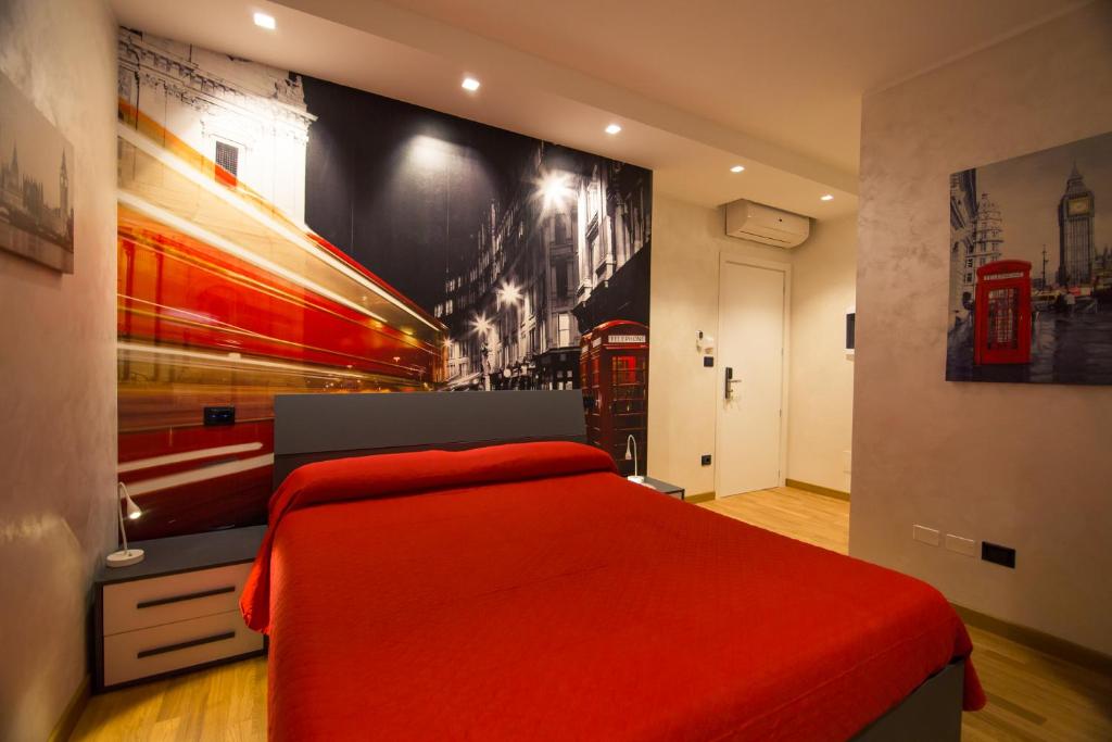 een slaapkamer met een rood bed en een muur met een foto bij Le mie città in Pescara