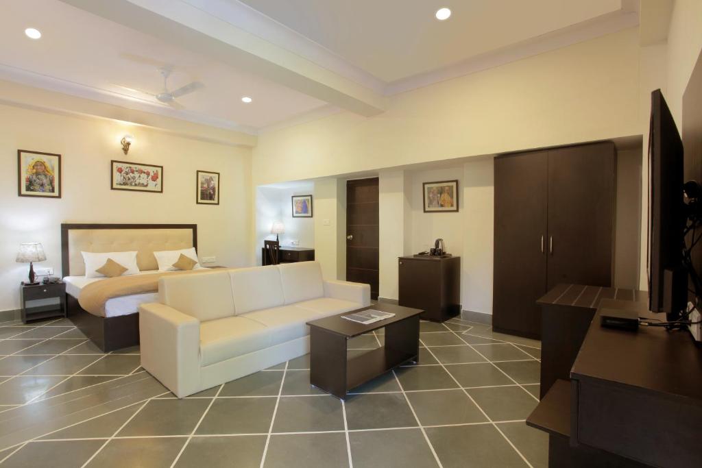 - un salon avec un canapé blanc et un lit dans l'établissement Mimosa Udaipur, à Udaipur