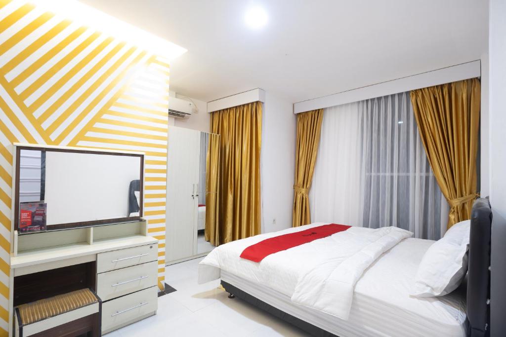 a bedroom with a bed and a flat screen tv at RedDoorz near IPB Dramaga Bogor in Bogor
