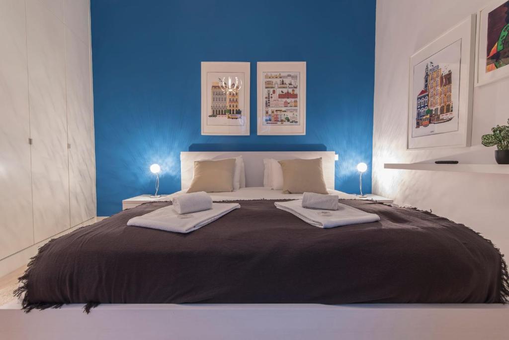 ein Schlafzimmer mit einem großen Bett mit blauer Wand in der Unterkunft LovelyStay - 3 Bedroom Downtown Wonderwall in Lissabon