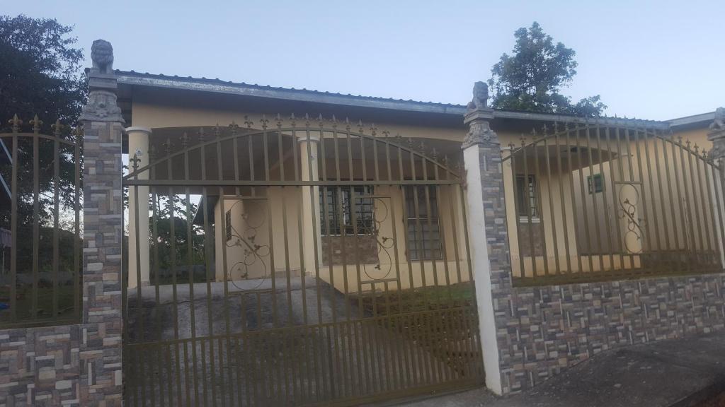 ein Haus mit einem Tor und einem Zaun in der Unterkunft Raquel House in Dolega
